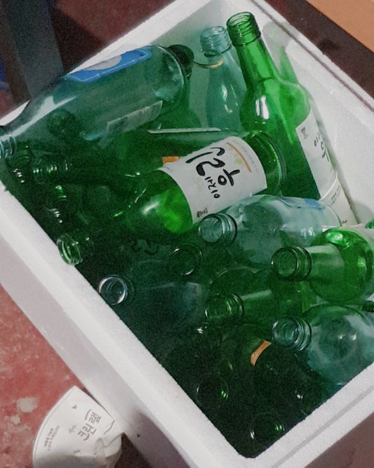 Table cluttered with empty soju and beer bottles after a heavy night out—ideal scenario for using Aldicom hangover relief for fast recovery.