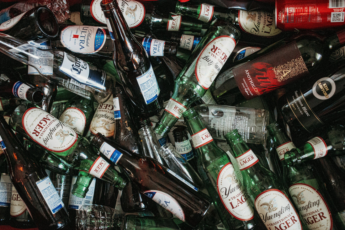 Pile of empty beer bottles and liquor containers after heavy drinking—highlighting the need for Aldicom’s herbal hangover remedy for detox and recovery