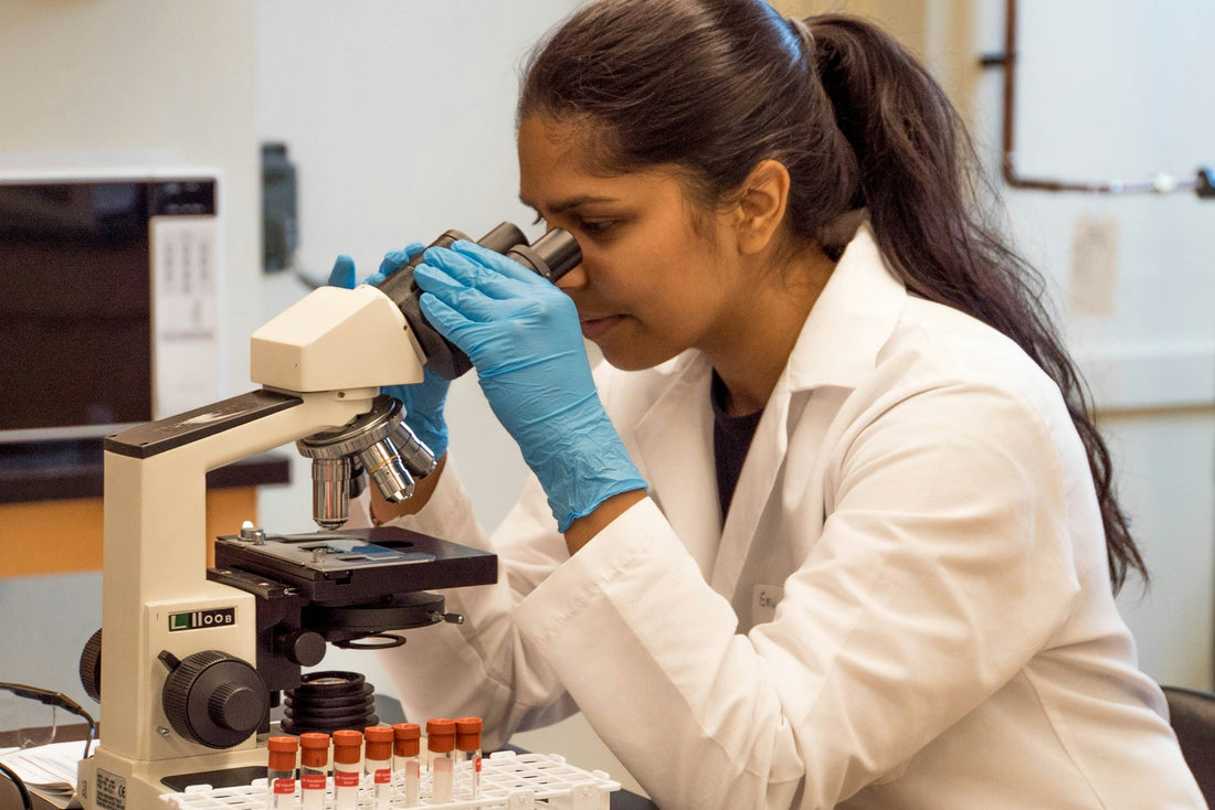 A young female scientist conducting research in a modern laboratory, symbolizing Aldicom’s science-backed formulation.